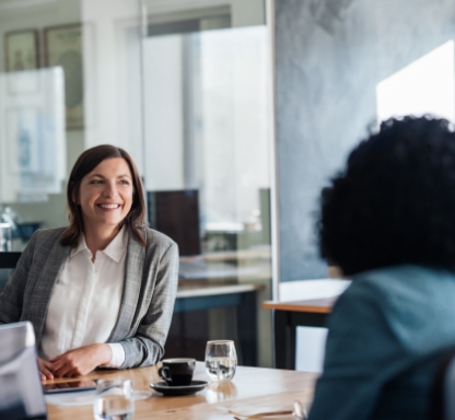 Woman sitting in a meeting with a smile.