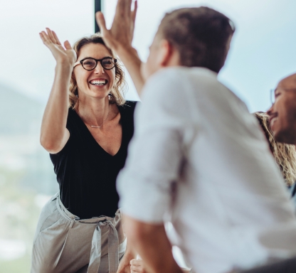 Woman high-fiving a coworker.